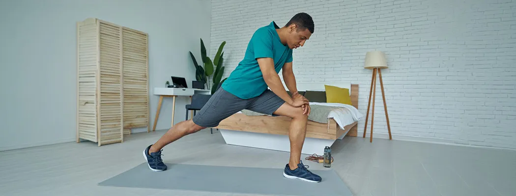 Person stretching to relieve knee pain during a workout.