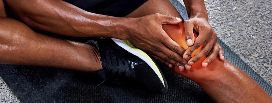 Person holding a painful knee after exercise.