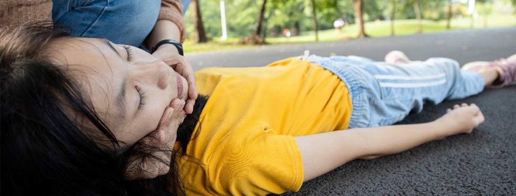 unconscious child lying on the road