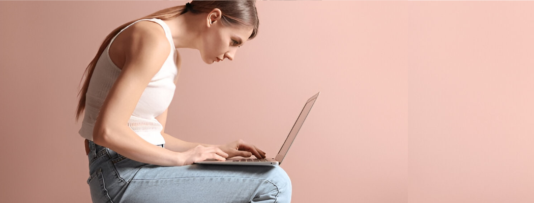 Woman with poor posture using a laptop